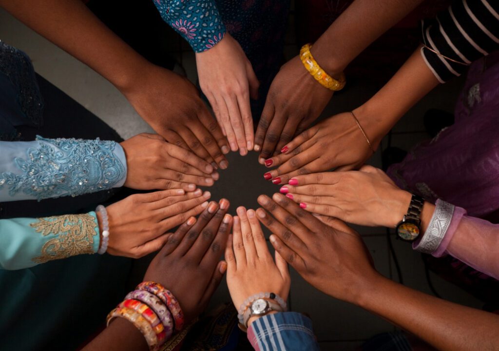 A group of people with their hands held together in solidarity.