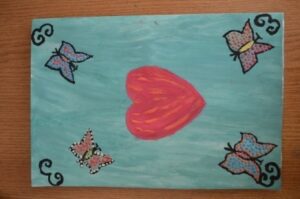 World Day Observance in Bistrita and Lasi, Romania poster ofa heart surrounded by butterflies by a child.