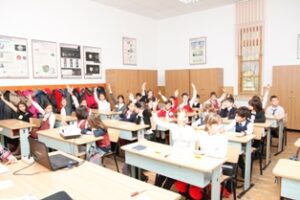 World Day Observance in Bistrita and Lasi, Romania children raising their hands in a classroom.